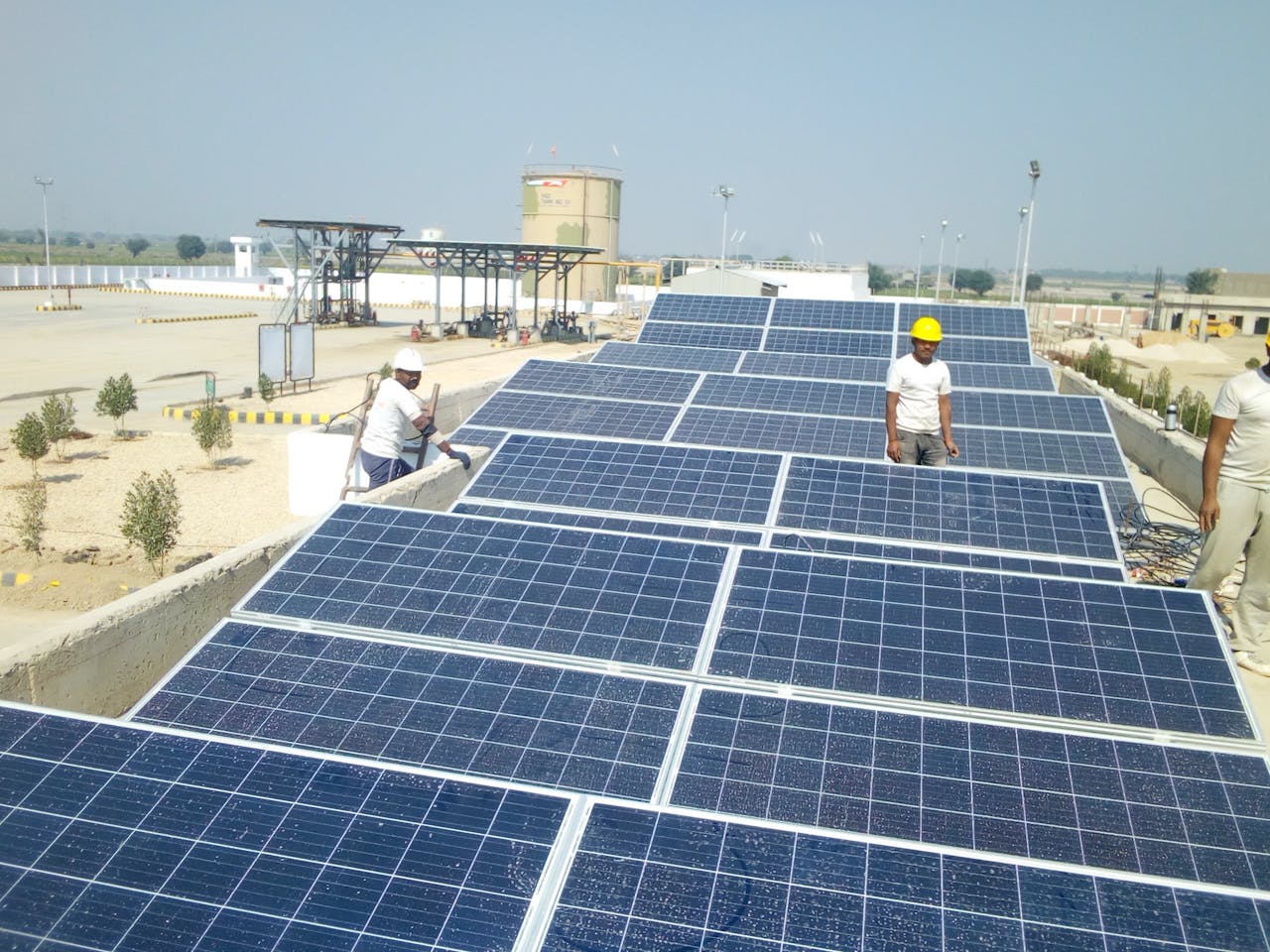 Workers installing solar panels on a rooftop for renewable energy generation.